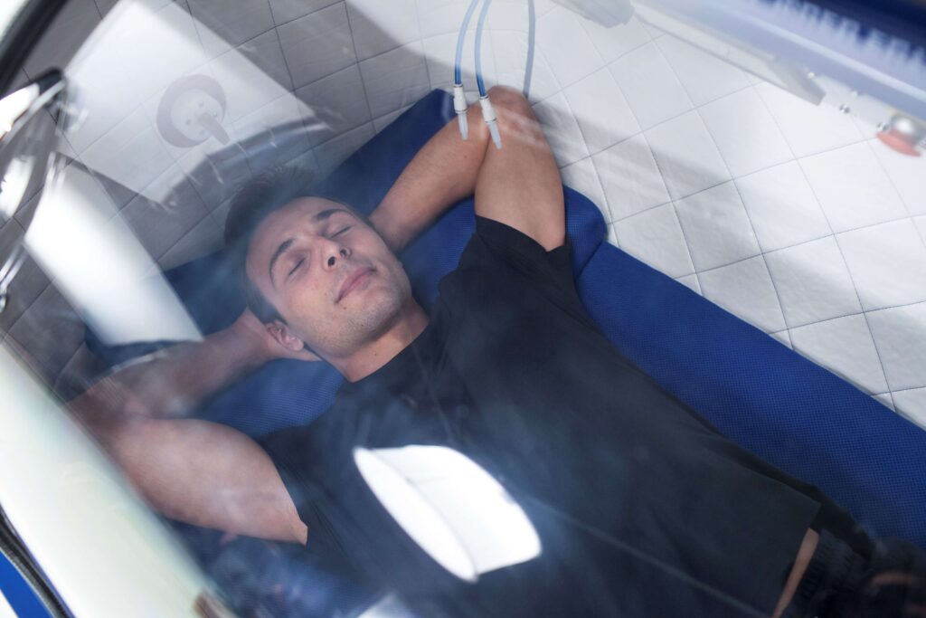 man laying in oxygen chamber